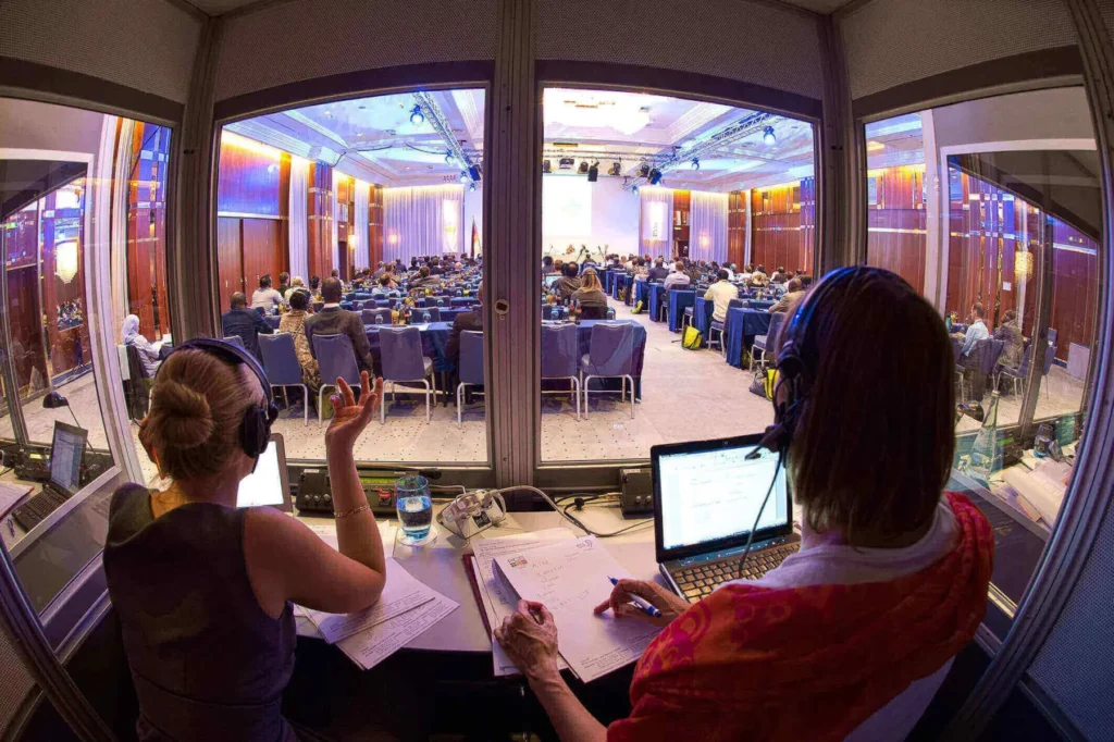 Interpreting services team working in simultaneous interpretation booth