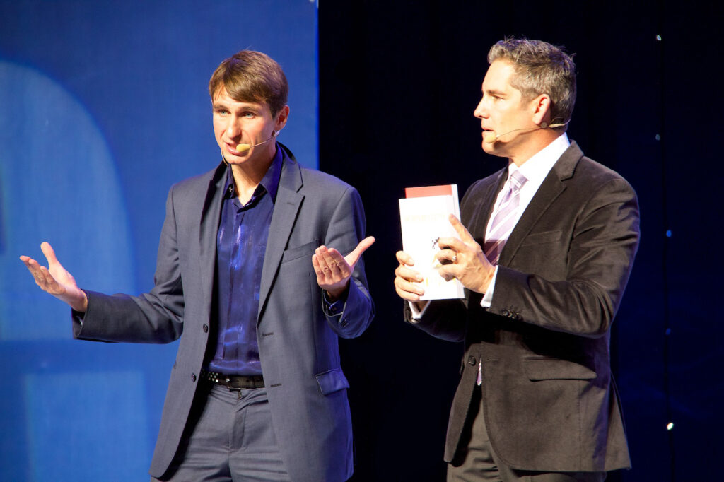 Vladimir Reznikov interpreting on stage beside Grant Cardone
