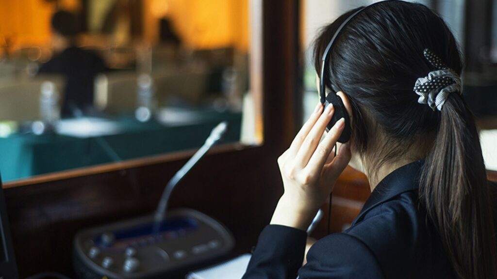 Simultaneous interpreting professional working in conference translation booth
